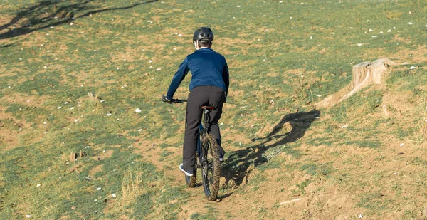 Cyclist in pants and fleece jacket on a modern carbon hardtail bike with an air suspension fork. The guy on the top of the hill rides a bike.