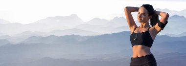 Zayıf bir atletik kız, sabahın erken saatlerinde dağların arka planında ders arasında mola verir. Sessizliğin ve özgürlüğün tadını çıkarır..