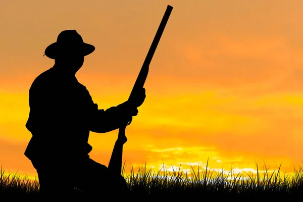 一个拿着枪在芦苇里对抗太阳的猎人的肖像 一个猎狗的鸭子的埋伏 — 图库照片