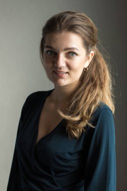 Arka planda, gölgeli gri bir duvarın üzerinde, penceresinden yansıyan doğal ışık olan güzel bir kızın portresi..