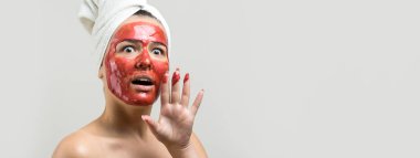 Yüzünde altın besleyici maske olan beyaz havluyla kadın portresi. Cilt temizleme eko organik kozmetik rahatlama konsepti. 