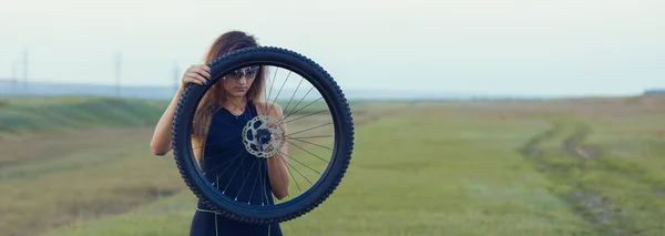 自転車修理 緑の丘の上でマウンテンバイクを修復する若い女の子 — ストック写真