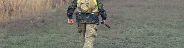 狩猟期間 秋のシーズンを開いています 秋の森の中でトロフィーを求めて狩猟服を手に銃を持ったハンター 男は武器と狩猟犬と一緒に立ってゲームを追跡する — ストック写真