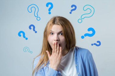 Düşünen genç bir kızın görüntüsü. Kameranın bir fikri var. Beyaz bir arkaplanda durur.