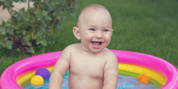 A small child is bathing in a pool, inflatable children\'s inflatable pool in summer