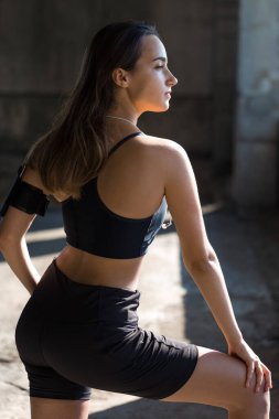 Spor giyimli, yılan derisi baskılı genç ve zayıf bir atletik kız bir takım egzersizler yapıyor. Fitness ve sağlıklı yaşam tarzı.