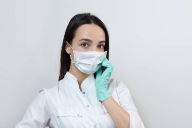 Lateks eldivenli ve beyaz önlüklü bir kız doktor ameliyata hazırlanıyor..