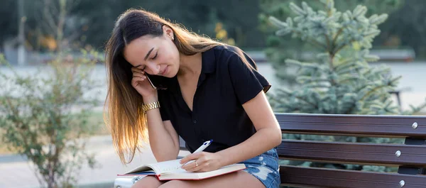 Una Joven Sienta Banco Parque Toma Notas Vestido Estilo Libre —  Fotos de Stock