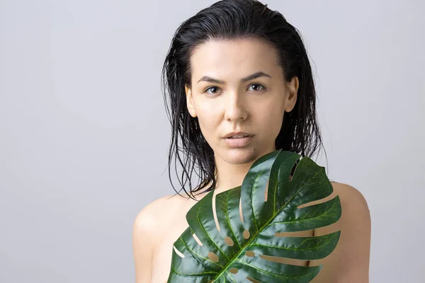 Beauty Woman with natural green palm leaf portrait. Fashion, beauty, make-up, cosmetics.