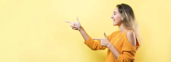 Jovem Mulher Caucasiana Feliz Uma Camisola Laranja Apontando Dedos Distância — Fotografia de Stock