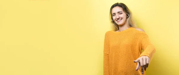 Happy Young Caucasian Female Orange Sweater Pointing Fingers Away — ストック写真