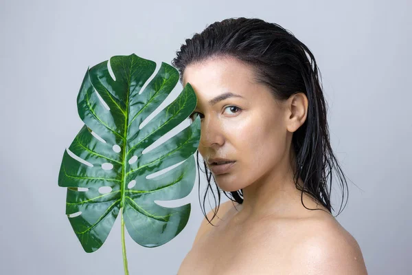 Beauty Woman with natural green palm leaf portrait. Fashion, beauty, make-up, cosmetics.