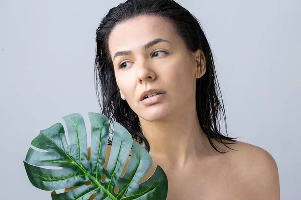 Beauty Woman with natural green palm leaf portrait. Fashion, beauty, make-up, cosmetics.