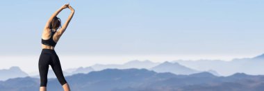 Zayıf bir atletik kız, sabahın erken saatlerinde dağların arka planında ders arasında mola verir. Sessizliğin ve özgürlüğün tadını çıkarır..