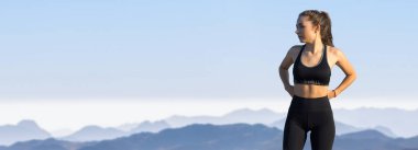 Zayıf bir atletik kız, sabahın erken saatlerinde dağların arka planında ders arasında mola verir. Sessizliğin ve özgürlüğün tadını çıkarır..