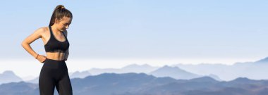 Zayıf bir atletik kız, sabahın erken saatlerinde dağların arka planında ders arasında mola verir. Sessizliğin ve özgürlüğün tadını çıkarır..