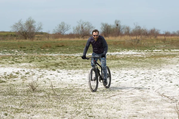 現代のマウンテンバイクで残酷な髭の男をスポーツ 湖に捨てられた塩の中のサイクリスト — ストック写真