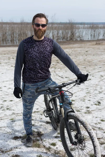 現代のマウンテンバイクで残酷な髭の男をスポーツ 湖に捨てられた塩の中のサイクリスト — ストック写真