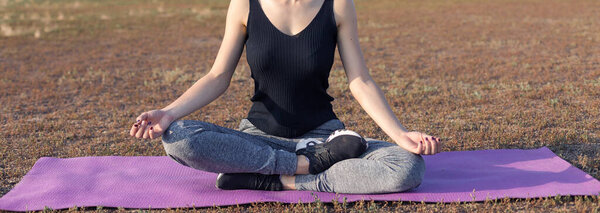 Молодая стройная спортивная девушка в спортивной одежде со змеиной шкурой выполняет ряд упражнений. Фитнес и здоровый образ жизни.