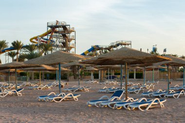 Güverte sandalyeleri ve şemsiyesiz sahil şeridi. Terk edilmiş tatil köyü.