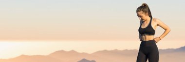 Zayıf bir atletik kız, sabahın erken saatlerinde dağların arka planında ders arasında mola verir. Sessizliğin ve özgürlüğün tadını çıkarır..