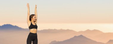 Zayıf bir atletik kız, sabahın erken saatlerinde dağların arka planında ders arasında mola verir. Sessizliğin ve özgürlüğün tadını çıkarır..