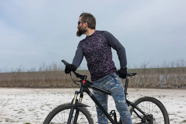 現代のマウンテンバイクで残酷な髭の男をスポーツ 湖に捨てられた塩の中のサイクリスト — ストック写真