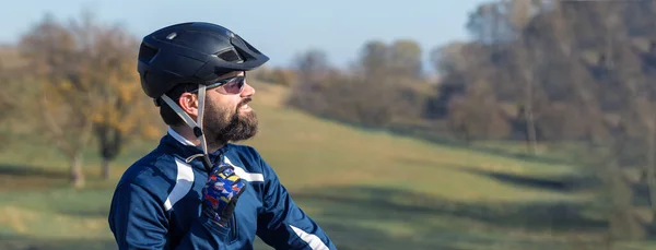 Cyclist in pants and fleece jacket on a modern carbon hardtail bike with an air suspension fork. The guy on the top of the hill rides a bike.