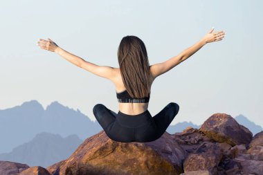 Zayıf bir atletik kız, sabahın erken saatlerinde dağların arka planında ders arasında mola verir. Sessizliğin ve özgürlüğün tadını çıkarır..