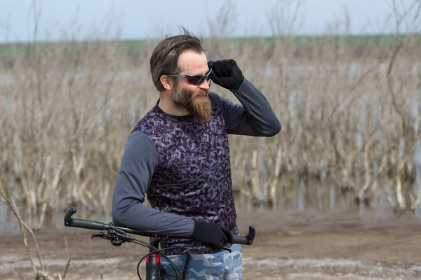 現代のマウンテンバイクで残酷な髭の男をスポーツ 湖に捨てられた塩の中のサイクリスト — ストック写真