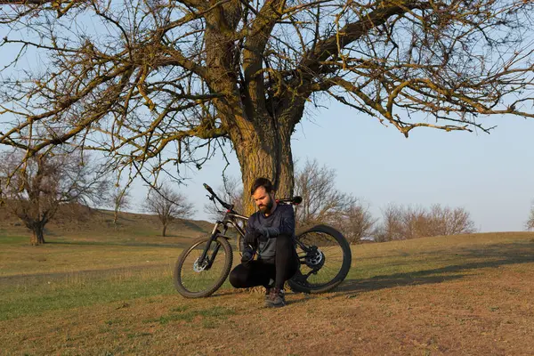 녹색의 배경으로 현수교가 경마장 자전거의 반바지와 저지를 자전거 — 스톡 사진