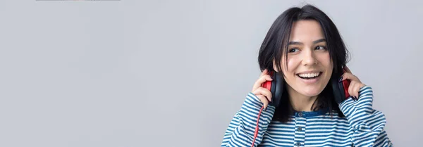 Una Joven Con Chaleco Rayas Está Escuchando Música Con Auriculares — Foto de Stock