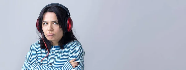 Ένα Νεαρό Κορίτσι Ριγέ Γιλέκο Ακούει Μουσική Κόκκινα Ακουστικά Ένα — Φωτογραφία Αρχείου