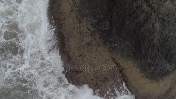 Tiro aéreo de ondas salpicando sobre as rochas — Vídeo de Stock