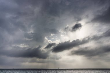 Denizin metalik renkler ile bulutlu gün batımı