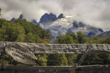 Ahşap çit ve sinyal ile arka planda dağlar