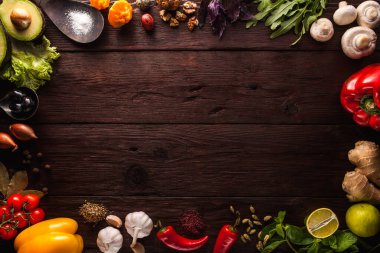Biber, sarımsak, zencefil, körfez yaprağı, baharatlar, kireç, ahşap arka planda tuz bulunan ahşap kaşık. Bedava metin alanı olan arkaplan düzeni. Uzayı kopyala Üst Manzara. Yemek düzdü.
