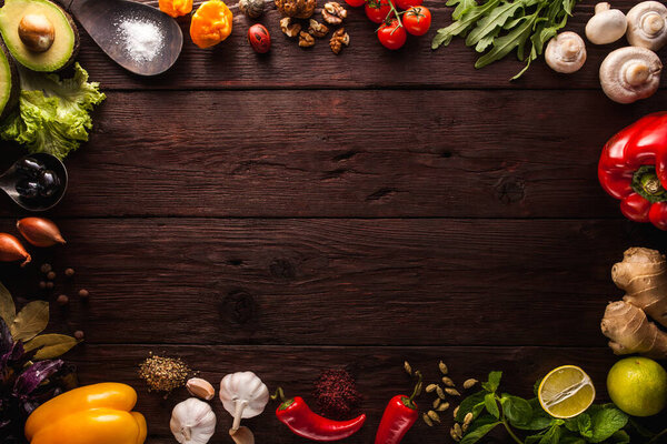 Перец, чеснок, имбирь, лавровый лист, специи, лайм, деревянная ложка с солью на темном деревянном фоне. Компоновка фона со свободным текстовым пространством. Принято. Вид сверху. Плоская еда
