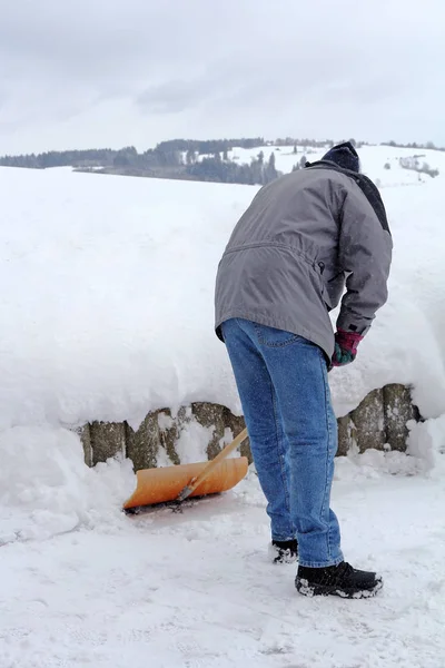 Чоловік лопає сніг на вулиці взимку. Чоловік лопає сніг — стокове фото