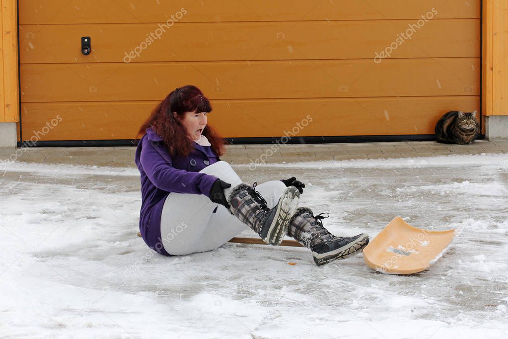 A woman has slipped and fallen while she is snipping