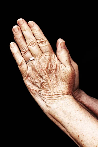 Handen van een oude vrouw te bidden — Stockfoto