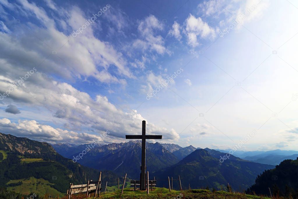 A summit cross in the evening light against the sky