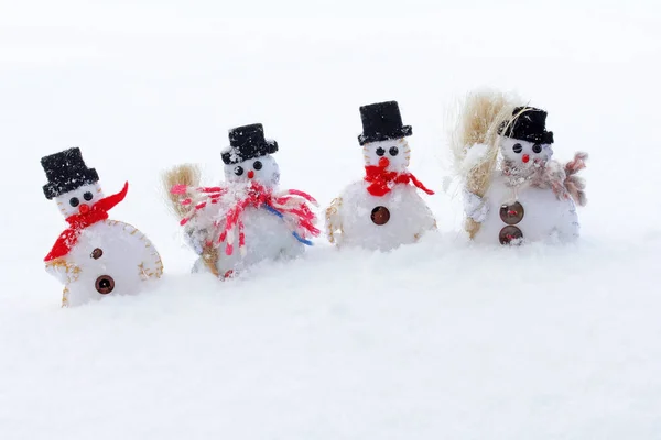 Vier sneeuwpoppen in koude sneeuw — Stockfoto