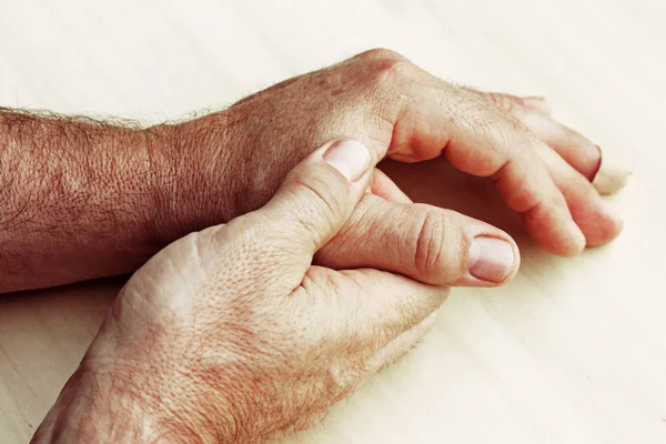 Un anciano tiene dolor en las manos. — Foto de Stock