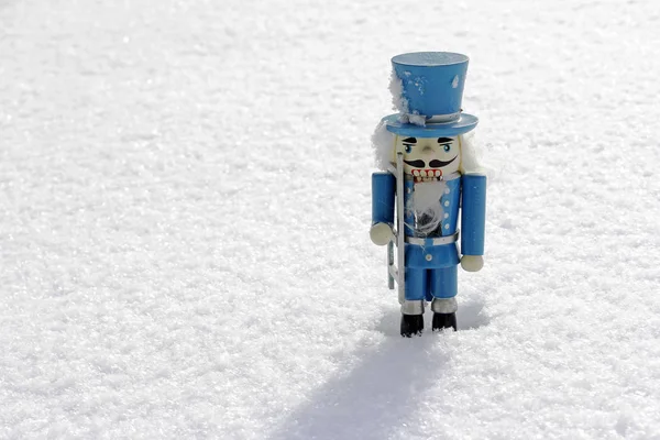 Un cascanueces azul de madera en la nieve — Foto de Stock