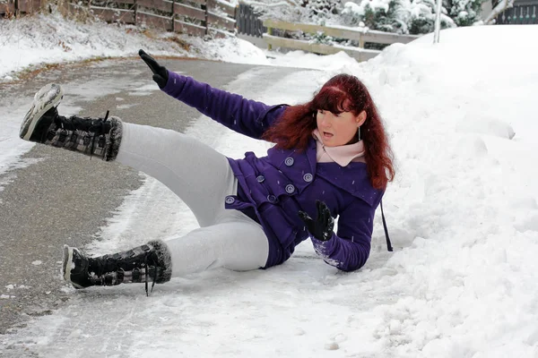 El peligro de accidente en invierno. Una mujer se escabulle por la suave calle —  Fotos de Stock