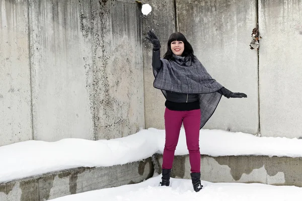 Diversão na neve - Uma jovem mulher joga uma bola de neve — Fotografia de Stock