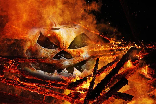 Une tête de citrouille effrayante dans le feu. Une tête de citrouille dans les flammes — Photo