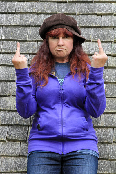 Пожилая женщина дерзко показывает вонючий палец. Несмотря на кризис среднего возраста. Оскорбление средним пальцем
