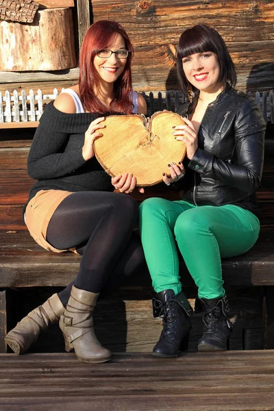 Le cœur de l'amitié. Deux jeunes femmes au cœur de bois — Photo